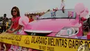 Seorang wanita duduk disamping sebuah mobil dengan dominan warna pink pada kontest modifikasi mobil di Automodfest 2014, Jakarta, Minggu (9/11/2014) (Liputan6.com/Andrian M Tunay)