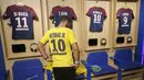 Seorang fans mencoba jersey pemain baru Paris Saint Germain, Neymar Jr, di toko merchandise di Paris, Jumat (4/8/2017). Setelah resmi bergabung dengan Paris Saint Germain, jersey Neymar Jr langsung diburu suporter klub Ibu kota. (AP/Michel Euler)