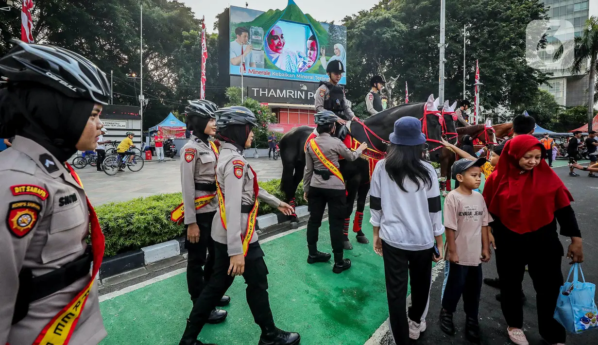 Selain mengambil gambar para polisi yang sedang menunggangi kuda, banyak warga yang minta foto bersama mereka. (Liputan6.com/Faizal Fanani)
