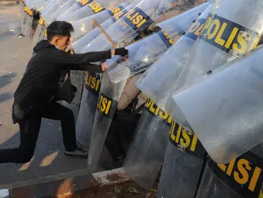 Massa aksi memukul polisi yang membentuk barikade dengan tameng di dekat Gedung DPR/MPR, Jalan Gatot Subroto, Jakarta, Senin (30/9/2019). Aksi unjuk rasa dari berbagai elemen tersebut menyikapi penolakan terhadap UU KPK dan sejumlah RUU yang dinilai bermasalah. (merdeka.com/Arie Basuki)