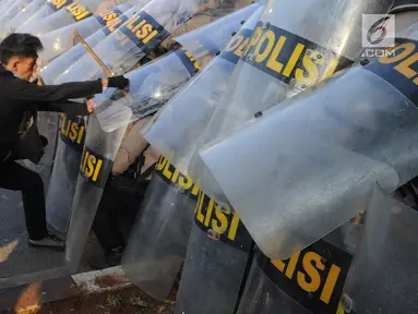 Massa aksi memukul polisi yang membentuk barikade dengan tameng di dekat Gedung DPR/MPR, Jalan Gatot Subroto, Jakarta, Senin (30/9/2019). Aksi unjuk rasa dari berbagai elemen tersebut menyikapi penolakan terhadap UU KPK dan sejumlah RUU yang dinilai bermasalah. (merdeka.com/Arie Basuki)