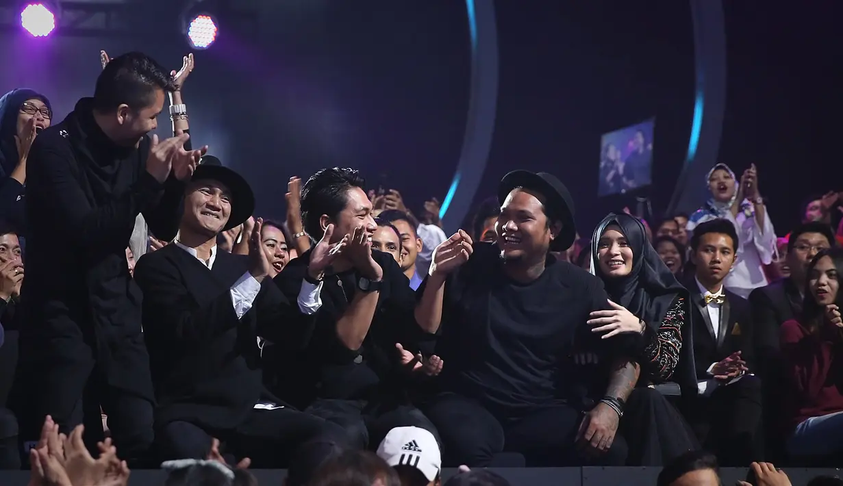 Ketika sedang berpegangan tangan dan berekspresi tegang, lagu Surat Cinta Untuk Starla hasil karya Virgoun pun disebut sebagai pemenang. Para nominator lain pun langsung bertepuk tangan. (Bambang E.Ros/Bintang.com)