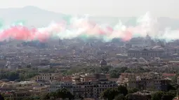 Asap berwarna bendera Italia yang dikeluarkan oleh tim aerobatik Frecce Tricolori selama parade militer ulang tahun Hari Republik Italia ke-72 di Roma, Sabtu (2/6). (AP Photo/Claudio Peri)