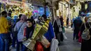 Untuk diketahui, lentera fanous merupakan lampion tradisional khas Mesir yang digunakan untuk menyambut bulan suci Ramadan. Tampak dalam foto, seorang wanita Mesir membawa lentera tradisional, yang dikenal secara lokal sebagai 'Fanous Ramadan', di pusat Kairo pada Kamis 12 Februari 2026. (Khaled DESOUKI/AFP)