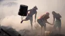 Warga berusaha memadamkan api dengan ember berisi air di Santa Ana, Asuncion, Paraguay, Kamis (19/8/2021). Api yang membakar kawasan pemukiman warga berpenghasilan rendah itu bermula dari orang-orang yang membakar sampah kemudian menjalar dan menghancurkan selusin rumah. (AP Photo/Jorge Saenz)