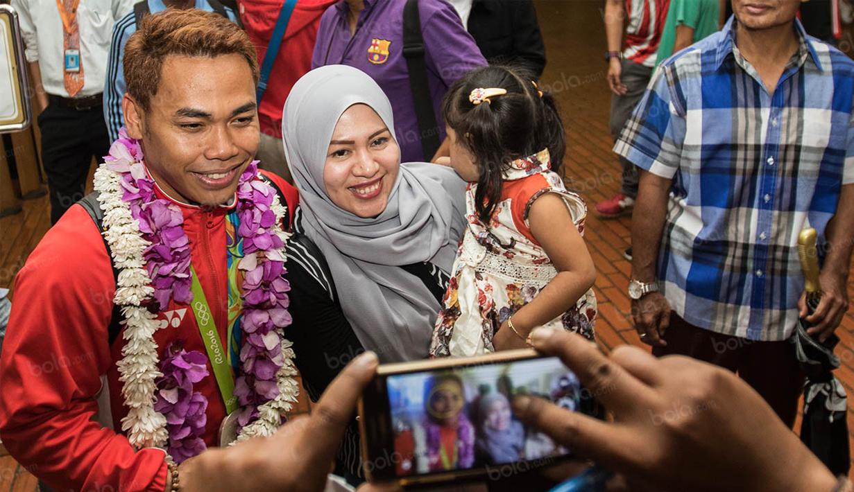 Peraih perak Olimpiade 2016 Rio de Janeiro cabang angkat besi kelas 62 kg, Eko Yuli, langsung melepas rindu dengan isteri dan anak saat kembali ke Indonesia. (Bola.com/Vitalis Yogi Trisna)