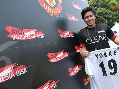 Salah satu fans Manchester United dengan bangga menunjukkan jersey bertanda tangan Dwight Yorke (Liputan6.com/Helmi Fithriansyah)