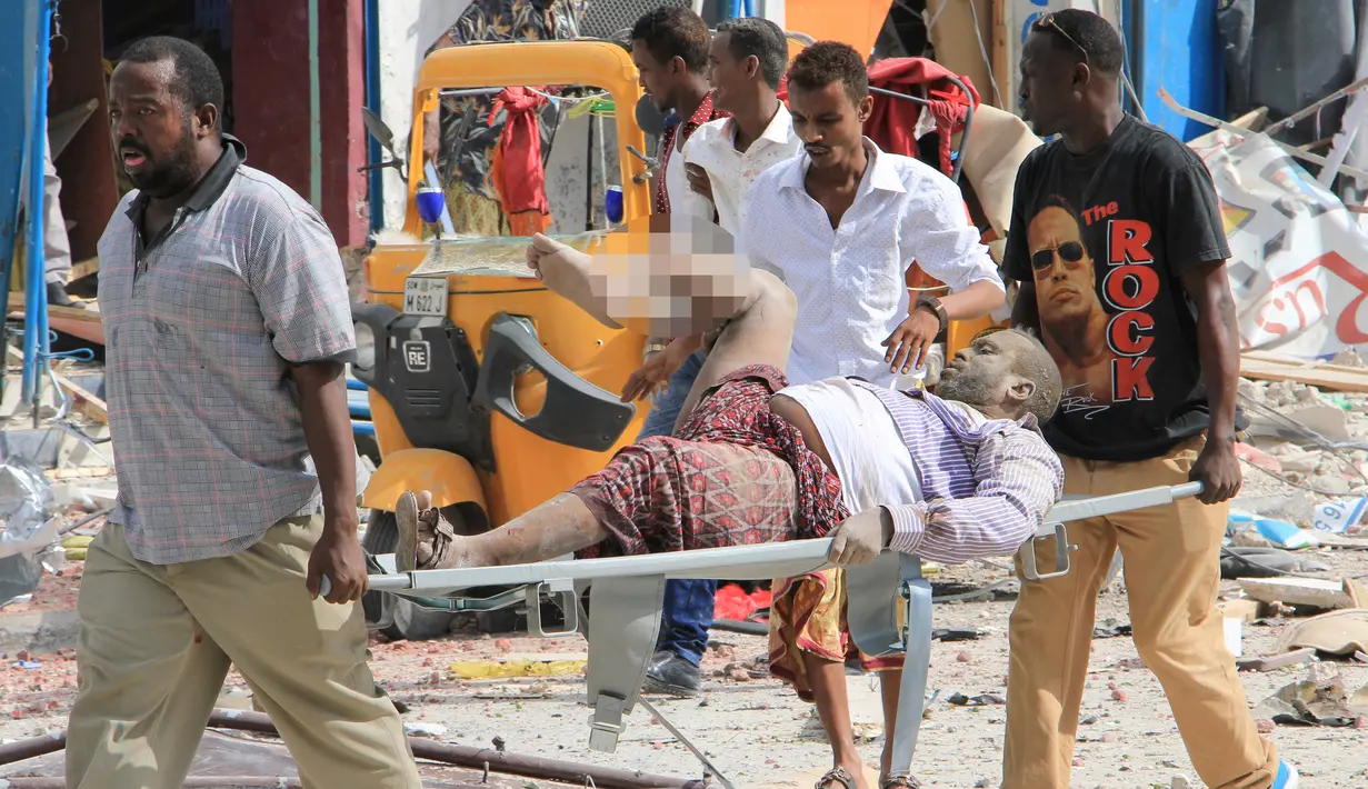 Petugas membawa korban dari serangan bom mobil di Mogadishu, Somalia, Rabu (25/1). Orang-orang yang terluka saat ini dilaporkan tengah mendapat perawatan di rumah sakit Hayad, yang terdekat dengan lokasi kejadian. (AP Photo)