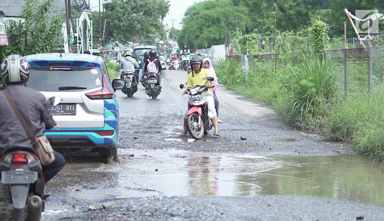 Kendaraan melintasi jalan yang rusak di Jalan Raya Gas Alam, Depok, Jawa Barat, Selasa (7/5). Kondisi jalan yang tidak kunjung diperbaiki tersebut menjadi kubangan air setiap hujan serta berbahaya bagi keselamatan pengguna jalan. (Liputan6.com/Immanuel Antonius)
