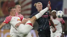 Penyerang Manchester City Erling Haaland berebut bola dengan bek RB Leipzig Lukas Klostermann pada laga matchday 2 Liga Champions 2023/2023 yang digelar di Red Bull Arena Leipzig, Kamis (5/10/2023) dini hari WIB. (AP Photo/Matthias Schrader)