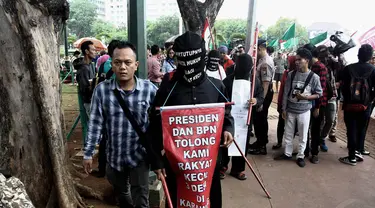 Aksi jalan kaki sambil menutup mata di depan Istana Negara, Jakarta, Selasa (18/11/2014). (Liputan6.com/Faizal Fanani)