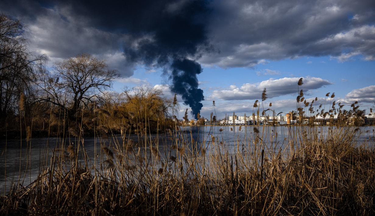 Asap mengepul setelah serangan rudal Rusia menghantam depot minyak di kota Vasylkiv di luar Kiev, Ukraina (27/2/2022). Menteri luar negeri Ukraina mengatakan pada 27 Februari, bahwa Kyiv tidak akan menyerah pada pembicaraan dengan Rusia mengenai invasinya. (AFP/Dimitar Dilkof)