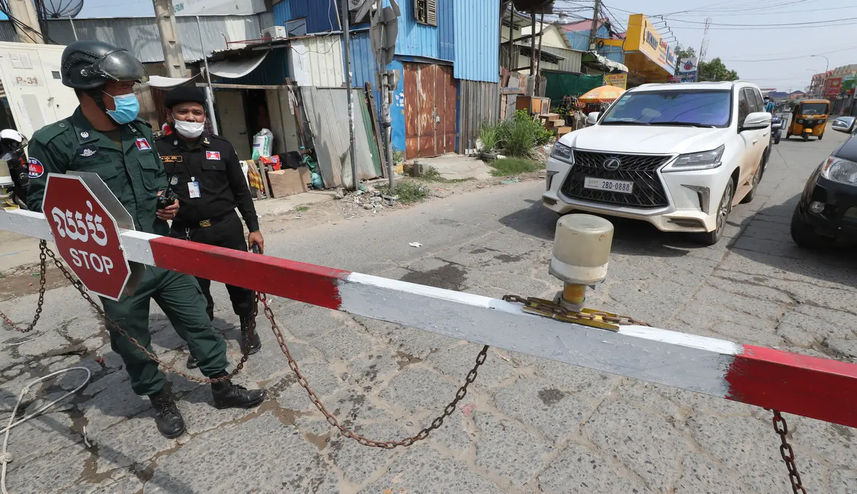 Petugas kepolisian setempat berjaga di jalan yang diblokir dekat bandara Internasional Phnom Penh di Phnom Penh, Kamis (15/4/2021). Pemimpin Kamboja memutuskan untuk lockdown atau karantina Phnom Penh selama dua minggu mulai Kamis (15/4) menyusul kenaikan tajam kasus COVID-19. (AP Photo/Heng Sinith)