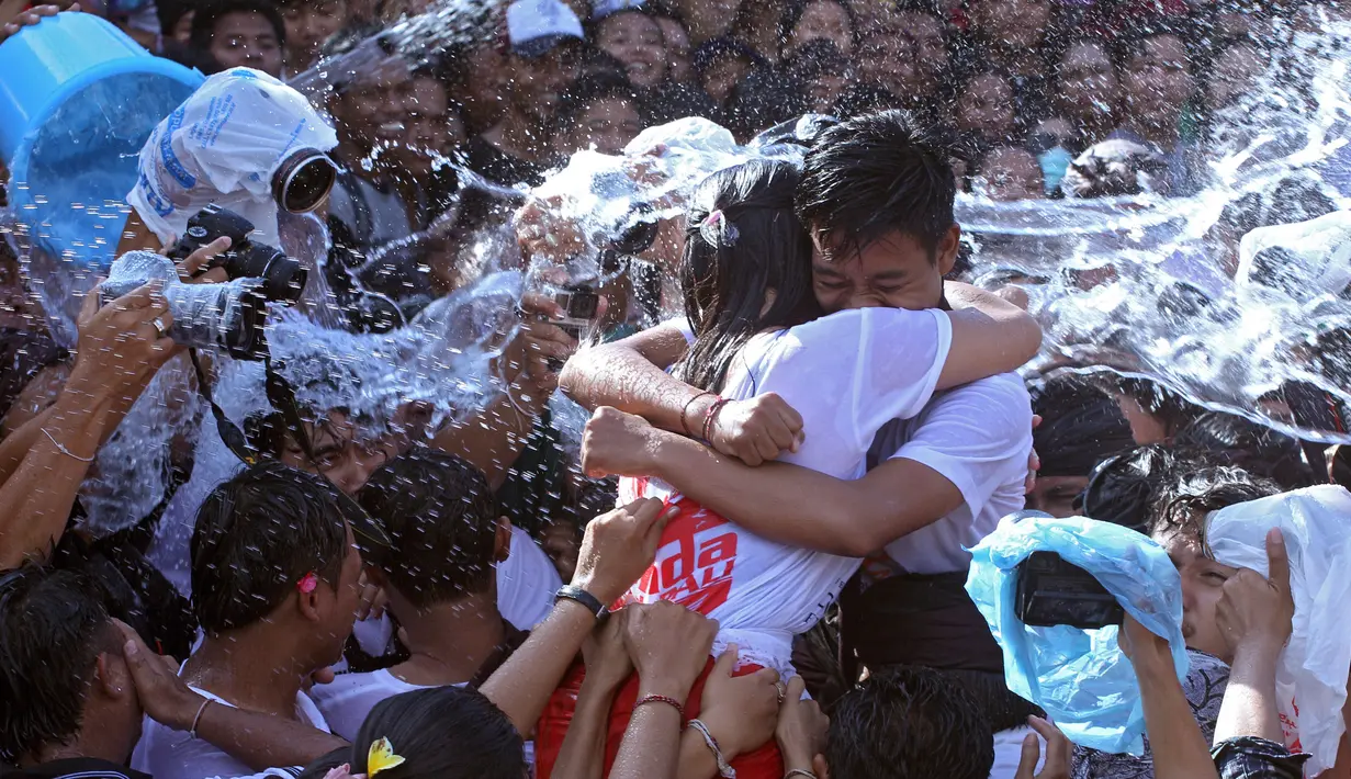 Sepasang remaja pria dan wanita saling berpelukan saat festival Omed-omedan di Bali, Kamis (29/3). Festival yang dilakukan sehari setelah Hari Raya Nyepi tersebut digelar untuk memupuk persaudaraan pemuda dan pemudi desa. (AP Photo/Firdia Lisnawati)