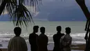 Warga melihat Gunung Krakatau (kiri) dan Anak Krakatau  di lepas pantai Carita, Banten (26/12). Pemerintah meminta warga menghindari pantai di daerah-daerah tersebut di mana tsunami telah menewaskan 420 jiwa akhir pekan lalu. (AP Photo/Achmad Ibrahim)