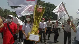 Dalam aksinya, Bara JP membawa trofi warna keemasan setinggi satu meter berbahan kardus di depan Istana Negara, Jakarta, (30/9/14). (Liputan6.com/Faizal Fanani)