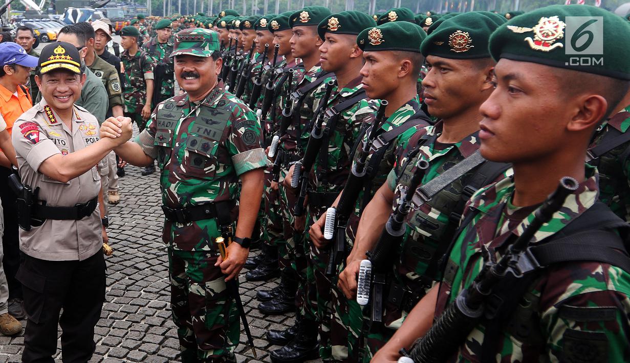 Panglima TNI Marsekal Hadi Tjahjanto dan Kapolri Jenderal Tito Karnavian melakukan salam Komando saat Apel Kesiapan Natal, Tahun Baru 2019 serta menjelang Pemilu legislasi dan Presiden 2019 di Monas, Jakarta, Jumat (30/11). (Liputan6.com/Johan Tallo)