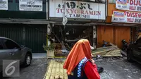 Warga saat melintasi restoran Jepang usai meledak di Jalan Boulevard Raya, Blok IA no 18, Jakarta, pada Senin malam, Selasa (21/7/2015). Ledakan diakibatkan oleh tabung gas yang berada di dapur masak. (Liputan6.com/Faizal Fanani)