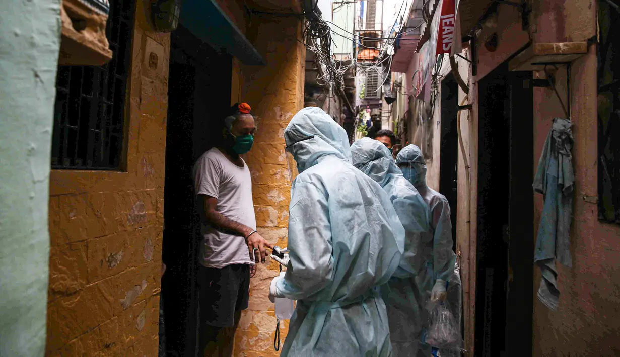 Petugas kesehatan India yang mengenakan alat pelindung diri melakukan pemeriksaan COVID-19 di kawasaan permukiman kumuh di tengah penyebaran wabah tersebut di Mumbai, India (17/6/2020). (Xinhua/Stringer)