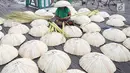 Perajin membuat caping khas Banjar di kawasan Pasar Apung Kuin, Kalimantan Selatan, Senin (26/3). Caping yang disebut tanggui oleh masyarakat Banjar tersebut merupakan topi tradisional khas Banjar. (Liputan6.com/Immanuel Antonius)