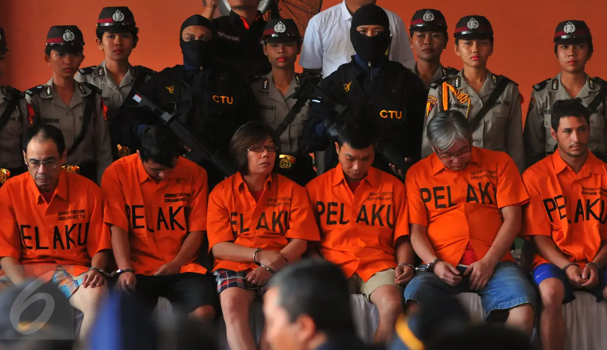Sejumlah pelaku dijaga ketat oleh pihak kepolisian di Bandara Soekarno Hatta, Tangerang, (16/2). Berbagai jenis barang tersebut nantinya kan dimusnahkan oleh pihak bea dan cukai. (Liputan6.com/Faisal R Syam)