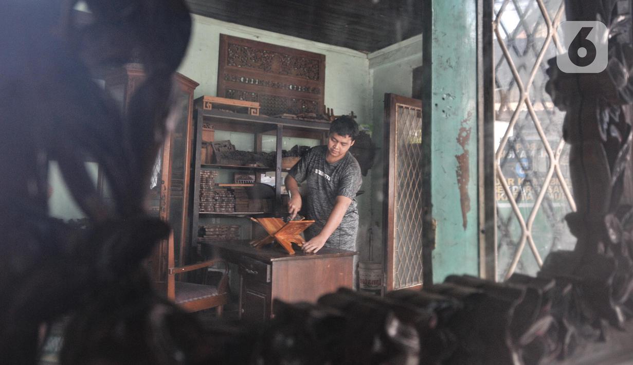 Pekerja menyelesaikan pembuatan rehal atau meja untuk Al-qur’an di Toko Mabruri 12, Klender, Jakarta, Rabu (13/4/2022). Harga rehal di toko ini dibanderol mulai dari Rp50.000 hingga Rp300 ribu per buah, tergantung ukuran dan jenis kayu. (merdeka.com/Iqbal S Nugroho)