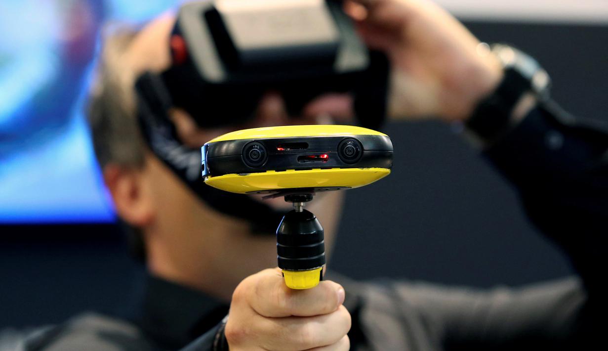 Seorang jurnalis mencoba kamera video Vuze 3D 360 di booth Vuze saat berlangsungnya Pameran Photokina di Cologne, Jerman, (20/9). Pameran ini berlangsung 20-25 September 2016. (REUTERS/Fabrizio Bensch)