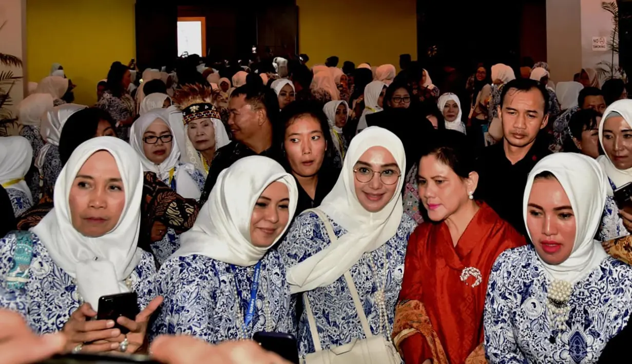Ibu Negara Iriana Joko Widodo foto bersama peserta saat menghadiri pembukaan Rakernas IWAPI XXVIII di Padang, Senin (8/10). Presiden Jokowi menyebut pengusaha perempuan memiliki modal besar untuk sukses. (Liputan6.com/Pool/Biro Pers Setpres)