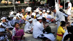 Suasana khusyuk saat umat Hindu tengah berdoa selama perayaan Kuningan di sebuah pura di Pulau Serangan, Denpasar, Bali, Sabtu (20/2). Kuningan merupakan hari terakhir dari perayaan Galungan. (AFP PHOTO/SONNY Tumbelaka)