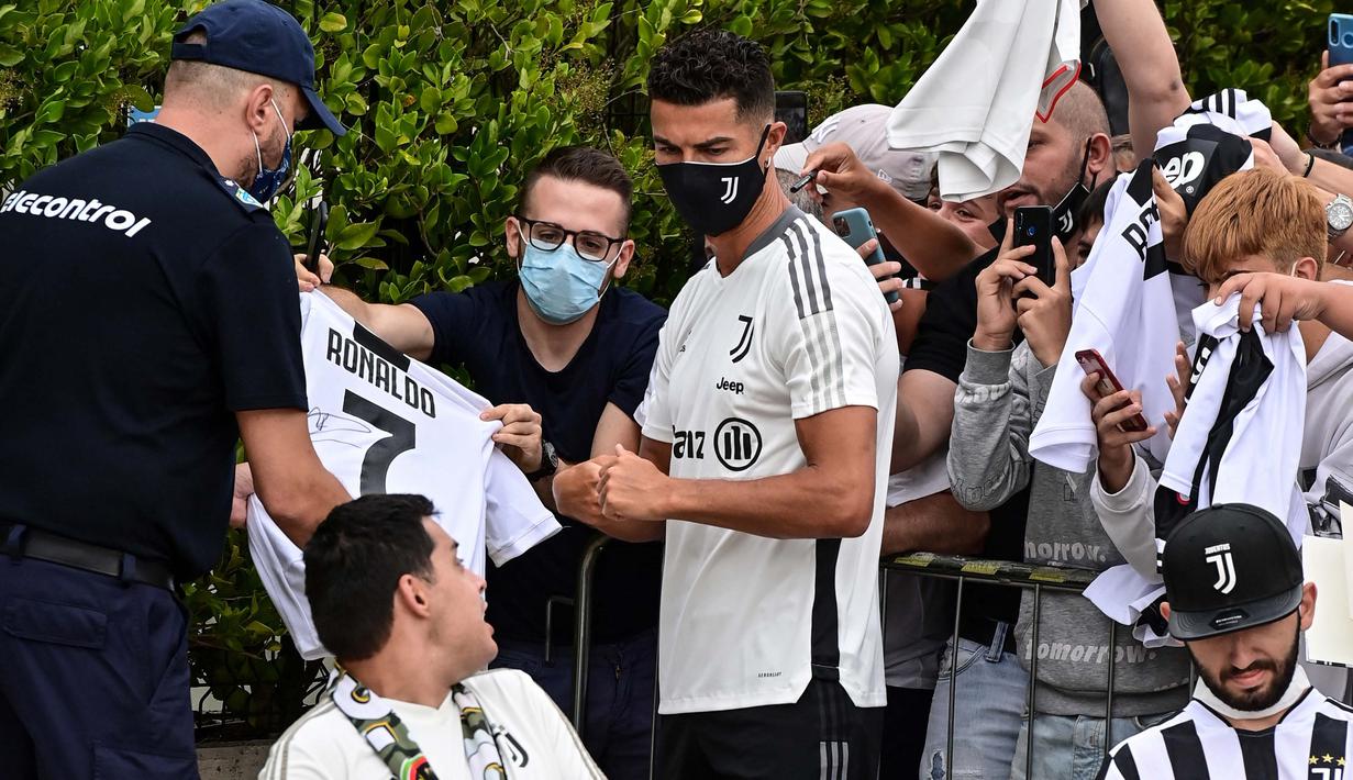 Bukan hanya swafoto, Cristiano Ronaldo pun menyempatkan menandatangani baju bola bernomor punggung 7 milik salah satu penggemar. (Foto: AFP/Miguel Medina)