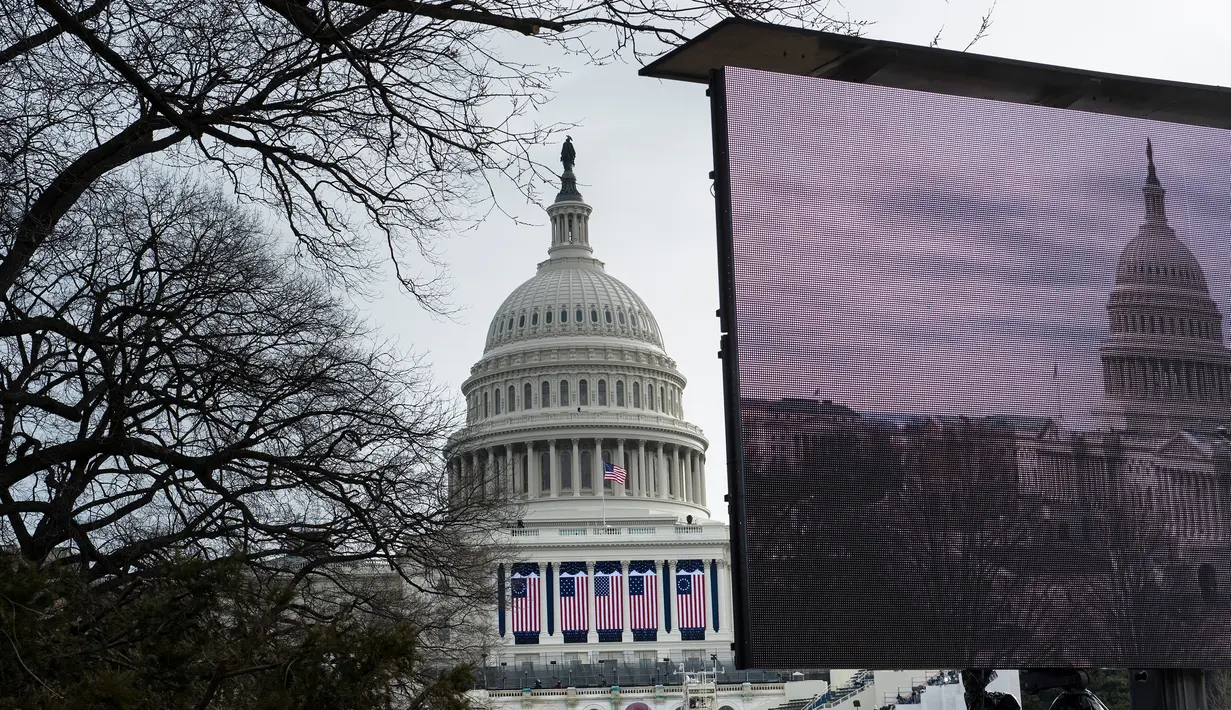 Layar besar disiapkan di sekitar halaman Gedung Capitol di Washington DC menyambut pelantikan presiden baru Donald Trump, Kamis (19/1). Diperkirakan sekitar 900.000 orang akan berkumpul untuk turut meramaikan prosesi itu. (AFP PHOTO/Brendan Smialowski)