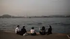 Orang-orang mengobrol di dermaga umum di sebelah Pelabuhan Victoria di Hong Kong (3/3). Pelabuhan ini merupakan tempat berkumpul yang populer bagi para turis dan penduduk. (AFP Photo/Dale De La Rey)