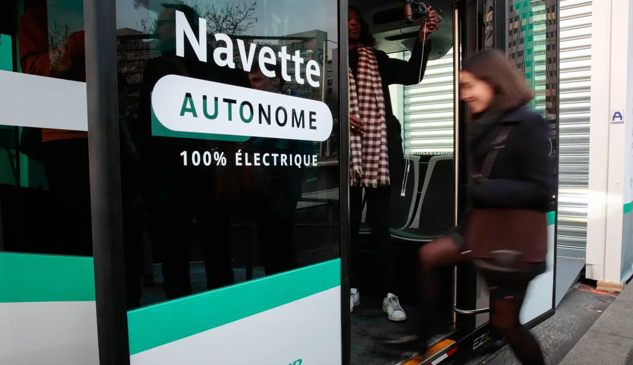 Seorang wanita menaiki bus tanpa supir (driverless) yang mulai dioperasikan di Paris, Senin (23/1). Bus tanpa sopir itu beroperasi di lajur khusus, berupa jembatan yang menghubungkan dua stasiun kereta, di timur pusat kota. (GEOFFROY VAN DER HASSELT/AFP)