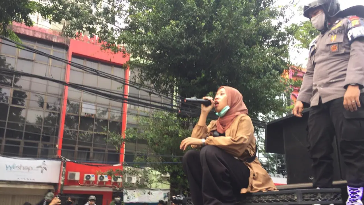 Aksi mahasiswi Qonita Syehsemala Universitas Islam Syekh-Yusuf (UNIS) Tangerang, bantu polisi tenangkan pendemo di Simpang Harmoni, Jakarta. (Liputan6.com/Radityo Priyasmoro)