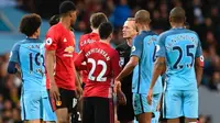 Para pemain Manchester City dan Manchester United melakukan protes kepada wasit Martin Atkinson pada laga Premier League di Stadion Etihad, Manchester, Kamis (27/4/2017). (AFP / Paul Ellis)