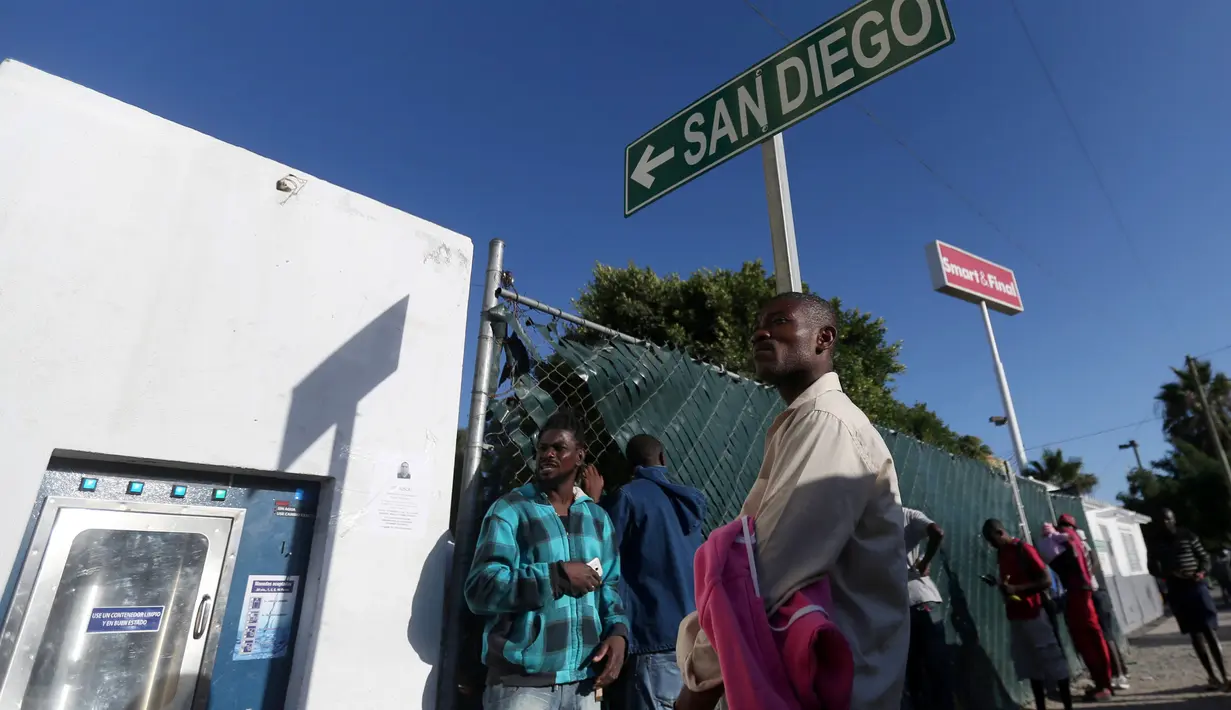 Sekelompok imigran Haiti meminta izin untuk tidur diluar penampungan Padre Chava, Tijuana, Meksiko, Senin (3/10). Setelah gempa Haiti yang terjadi pada 2010, mereka pindah ke beberapa negara dan akan melanjutkan ke AS. (REUTERS/Edgard Garrido)