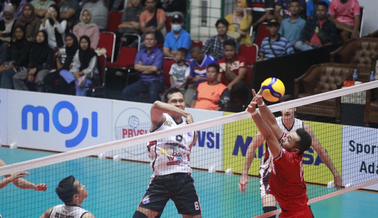 <p>Pemain Jakarta LavAni Allo Bank Electric, Muhammad Malizi (tengah) melepaskan spike yang berusaha diblok pemain Kudus Sukun Badak, I Putu Randu pada laga seri keempat putaran pertama PLN Mobile Proliga 2024 di GOR Tri Dharma Petrokimia, Gresik, Jawa Timur, Jumat (17/5/2024). Jakarta LavAni Allo Bank Electric menang 1-3-1 (31-29, 25-23, 25-27 dan 25-13). (Dok. PBVSI)</p>