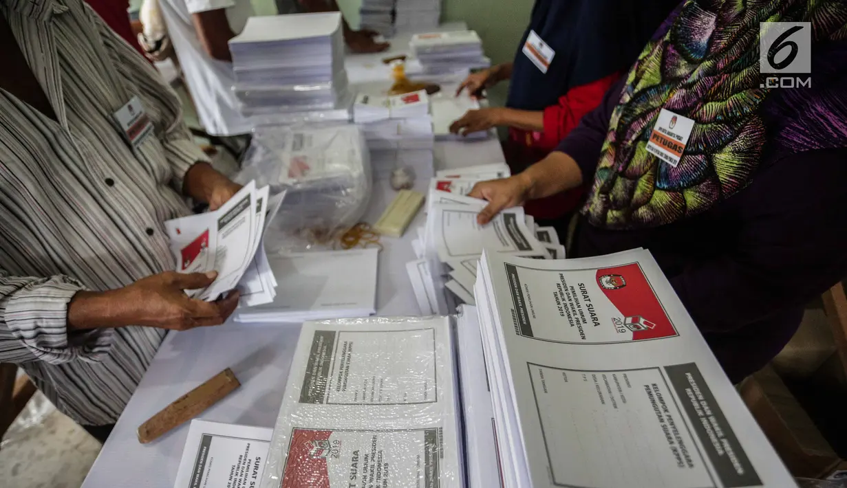 Sejumlah pekerja melipat surat suara Pemilihan Umum 2019 di gudang logistik KPU Jakarta Pusat, Selasa (19/2). Tugas pertama para pekerja ialah menyortir surat suara antara surat suara yang cacat dan yang tidak cacat. (Liputan6.com/Faizal Fanani)