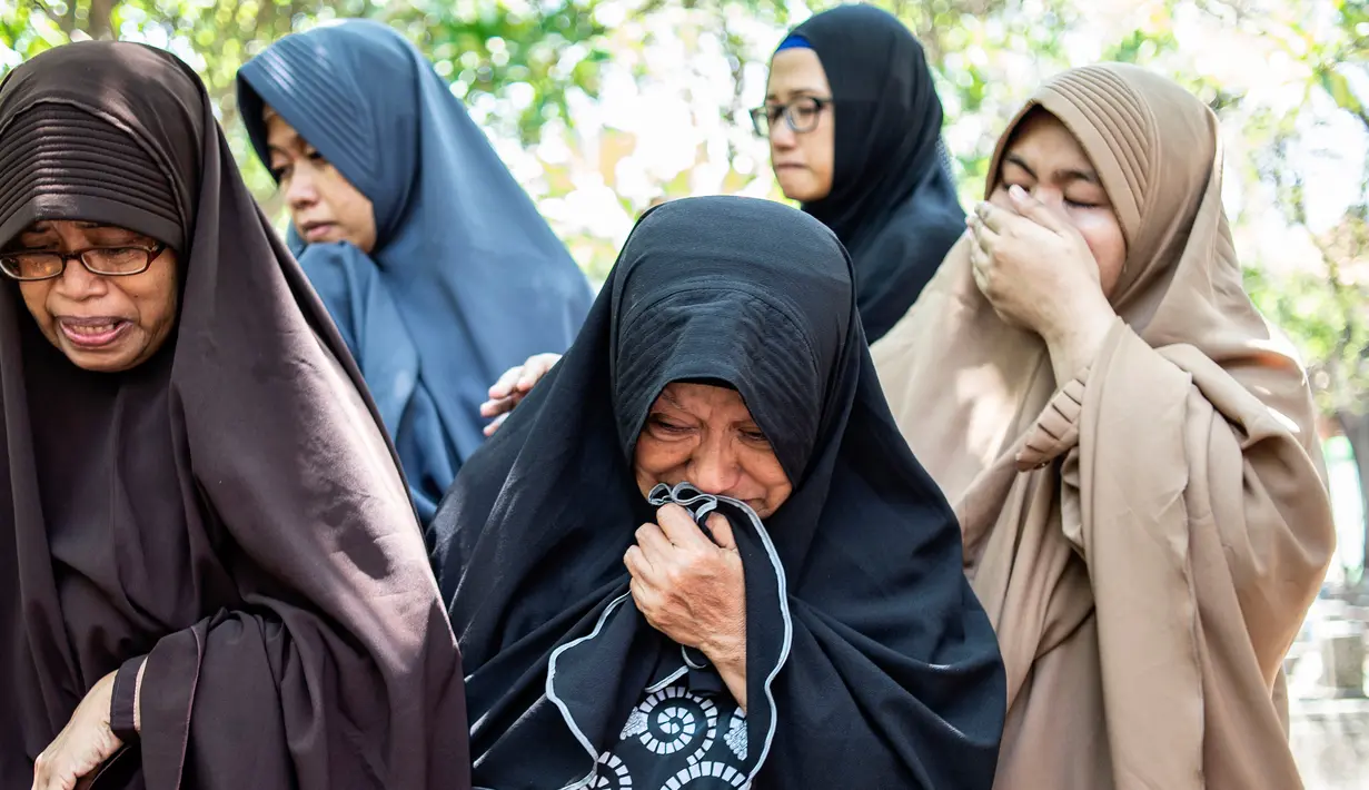 Kesedihan bibi (kiri) dari penyelam Syachrul Anto yang meninggal dunia kala melakukan evakuasi jatuhnya pesawat Lion Air PK-LQP, saat pemakaman di Surabaya, Jawa Timur, Sabtu (3/11). Syachrul meninggal karena dekompresi. (JUNI KRISWANTO/AFP)