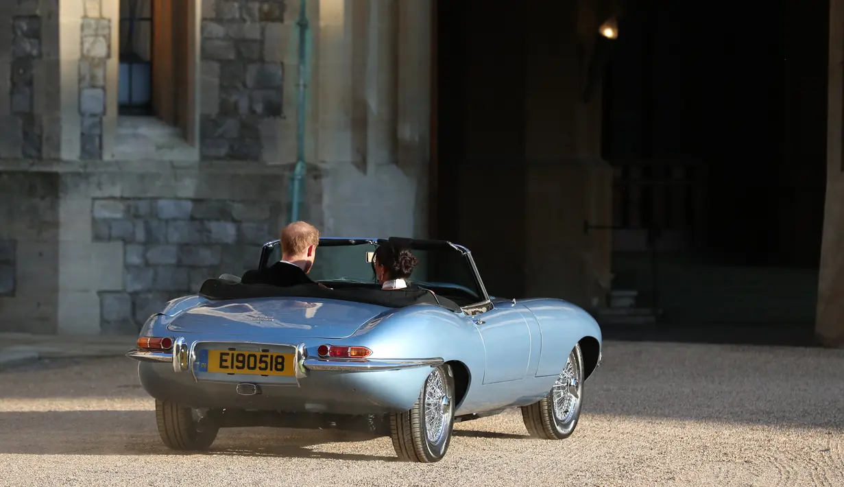Pangeran Harry dan istrinya Meghan Markle meninggalkan Kastil Windsor untuk ke acara resepsi dekat Frogmore House (19/5). Jaguar Classic E-Type Concept Zero merupakan mobil telah disulap menjadi mobil bertenaga listrik . (AFP Photo/Pool/Steve Parsons)
