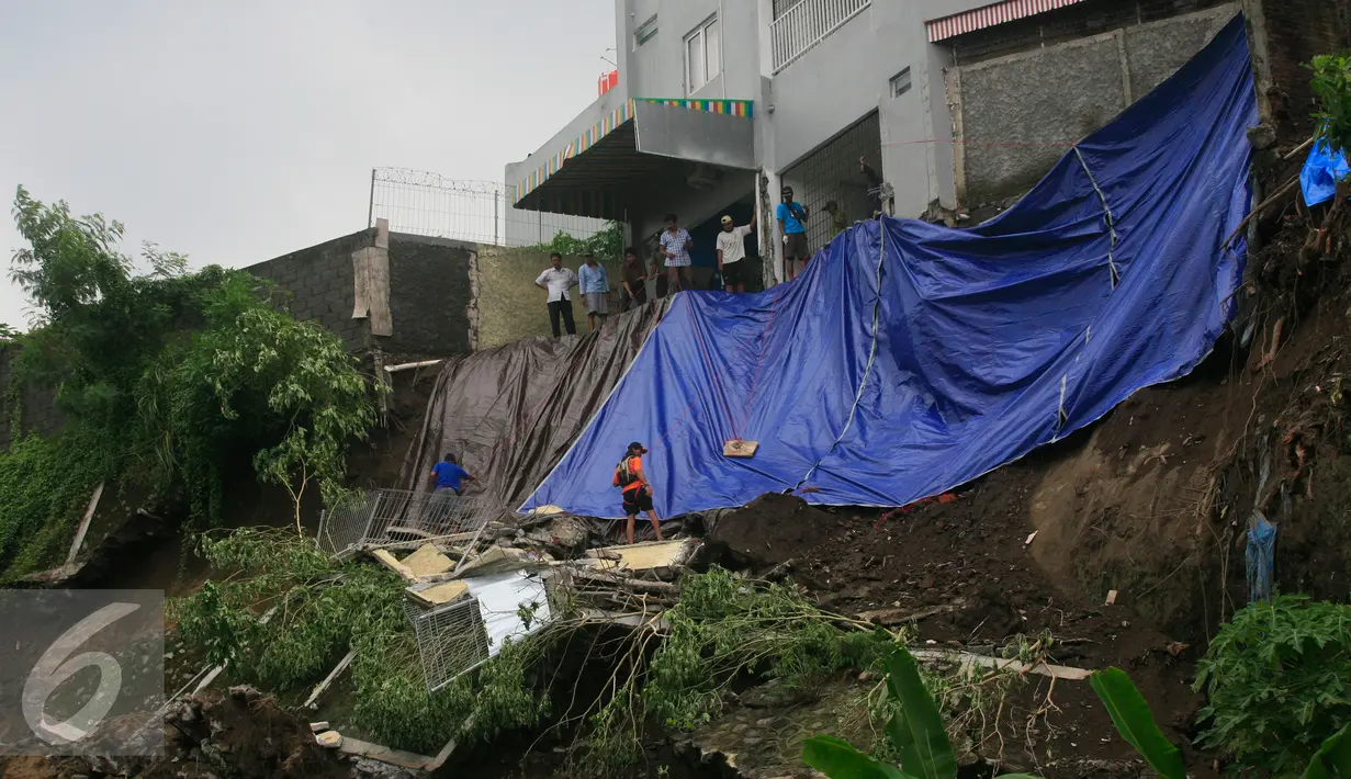 Tim SAR memasang terpal untuk mengantispasi terjadinya longsor susulan di bantaran Kali Code, Yogyakarta, Rabu (30/3). Longsor terjadi akibat hujan deras yang terjadi pada pagi hari. (Liputan6.com/Boy Harjanto)
