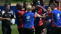 Pelatih Kanada AS Jesse Marsch (kiri) menyaksikan bek Kanada #15 Moise Lumpungu (tengah) diajak bercanda oleh rekan satu timnya selama sesi Latihan sehari sebelum semifinal Copa America 2024 di Basking Ridge, New Jersey, Senin (8/7/2024). (JUAN MABROMATA / AFP)