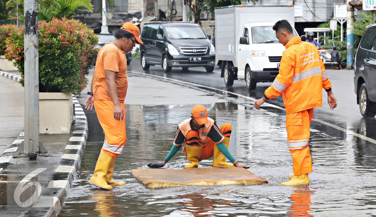 Petugas menggunakan busa untuk membersihkan genangan air di Harmoni, Jakarta, Selasa (9/2). Buruknya sistem drainase membuat petugas terpaksa harus membersihkan genangan setiap kali hujan, meski dengan peralatan seadanya. (Liputan6.com/Immanuel Antonius)