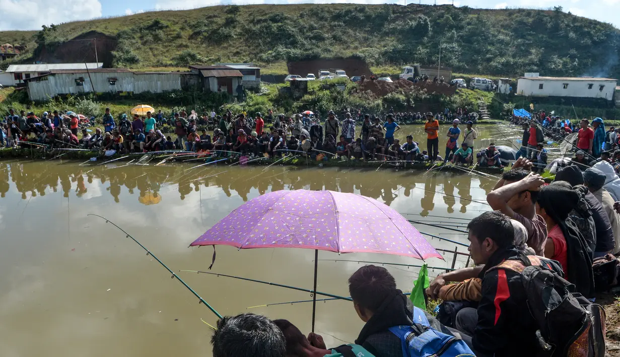 Para peserta pria mengikuti kompetisi memancing di sebuah kolam dekat desa Weilei di Negara Bagian Meghalaya, timur laut India, Sabtu (21/9/2019). Ratusan peserta berpartisipasi dalam kompetisi yang memperebutkan sejumlah hadia tersebut. (DIPTENDU DUTTA / AFP)
