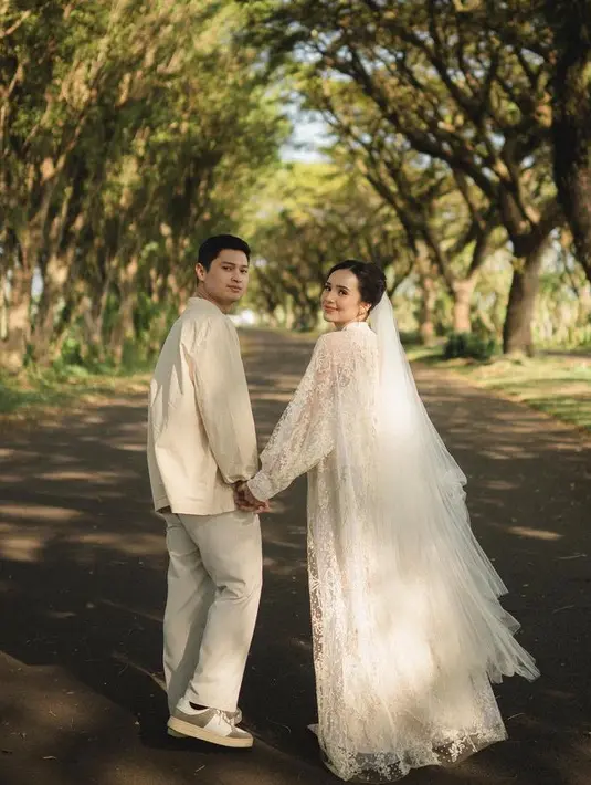 <p>Dress lace tersebut dipadukan dengan veil bertumpuk putih yang memaksimalkan tampilannya. Sedangkan sang calon suami mengenakan kemeja lengan panjang beige dipadukan celana panjang warna senada. [@bebytsabina]</p>