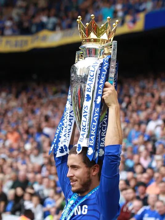 Gelandang Chelsea, Eden Hazard mengangkat trofi saat perayaan gelar juara Premier League 2014-15 di Stamford Bridge, Minggu (24/5/2015). Ini merupakan trofi pertama Thibaut Courtois di Premier League. (Reuters/John Sibley)