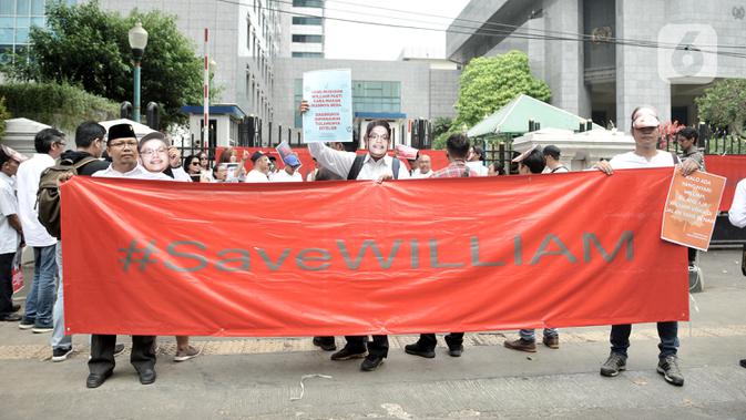 Massa Aliansi Masyarakat Untuk Transparansi mengenakan topeng William Aditya dan membentangkan poster saat aksi damai di Gedung DPRD DKI Jakarta, Rabu (4/12/2019). Mereka menuntut Badan Kehormatan DPRD Jakarta menghormati serta mendukung anggota DPRD dari fraksi PSI itu (merdeka.com/Iqbal S Nugroho)