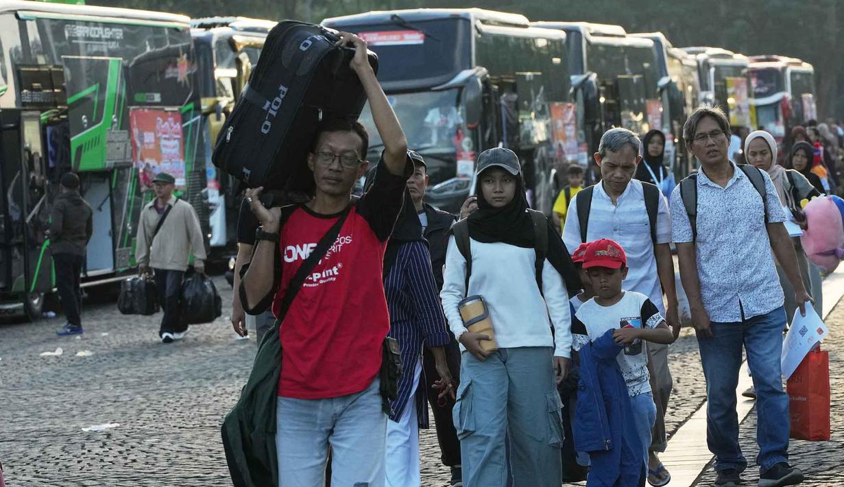 Program bertajuk "Aman Nyaman Bawa Cerita Bahagia" ini menggunakan 709 bus ke 20 kota/kabupaten tujuan. Tampak dalam foto, orang-orang membawa barang-barang mereka saat tiba untuk perjalanan mudik gratis yang diselenggarakan oleh Pemerintah Provinsi Jakarta di Lapangan Monumen Nasional, Selasa 17 Maret 2026. (AP Photo/Achmad Ibrahim)