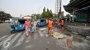 Petugas PPSU melakukan penambalan pada jalan yang berlubang di wilayah Senen, Jakarta, Selasa (26/7). Penambalan jalan berlubang ini bertujuan untuk kenyamanan pengguna jalan yang melintas. (Liputan6.com/Yoppy Renato)