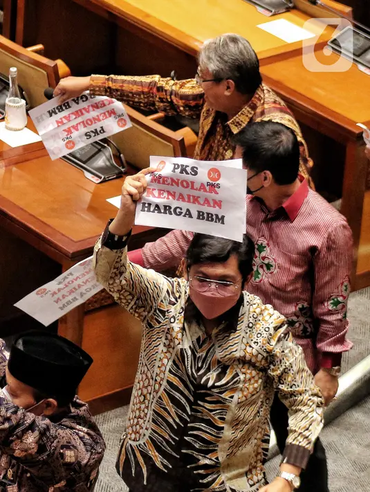 Anggota Fraksi PKS memegang poster bertuliskan “Tolak Kenaikan Harga BBM” walkout dari Rapat Paripurna ke-4 masa persidangan I tahun 2022-2023 di Kompleks Parlemen, Senayan, Jakarta, Selasa (6/9/2022). Fraksi PKS menyampaikan interupsi dan dilanjutkan melakukan walk out keluar dari ruang paripurna. (Liputan6.com/Angga Yuniar)